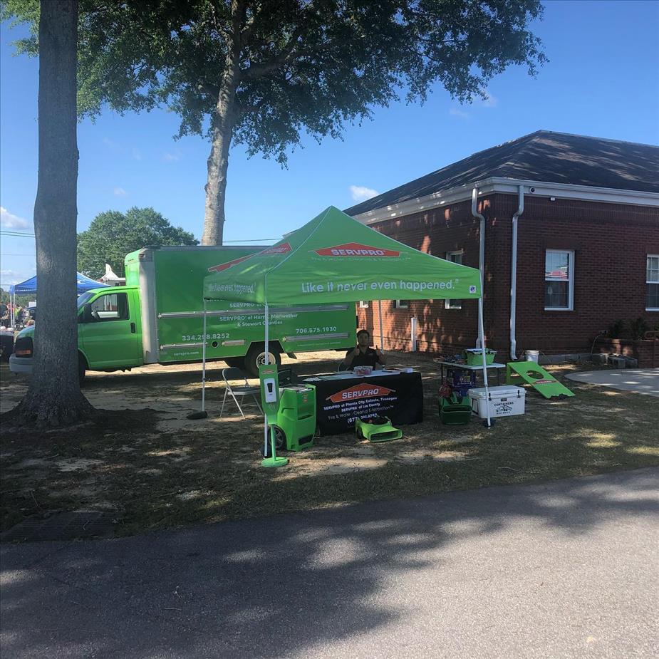 Photo shows green SERVPRO tent and equipment setup at an event